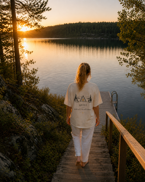 A woman walking down a wooden jetty at sunset in the Quiet Is a Destination tee